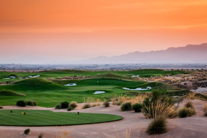 Championship desert golf course with dramatic sunset sky — custom golf travel itineraries by Fort Collins travel advisor Cathy at Amore Travel Designs
