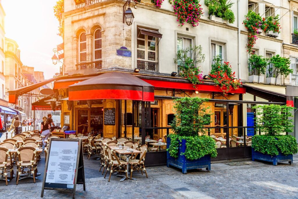 Charming Parisian café scene with outdoor seating, perfect for luxury European travel inspiration with Amore Travel Designs.