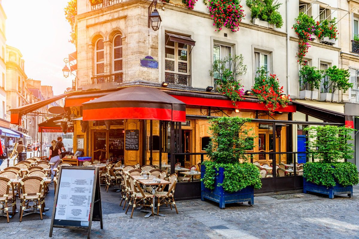 Charming Parisian café scene with outdoor seating, perfect for luxury European travel inspiration with Amore Travel Designs.