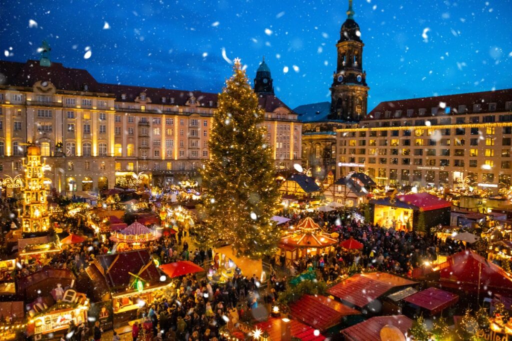 Elegant Christmas market in Germany with twinkling lights and luxury travelers exploring festive stalls, curated by Amore Travel Designs, Fort Collins luxury travel advisor.