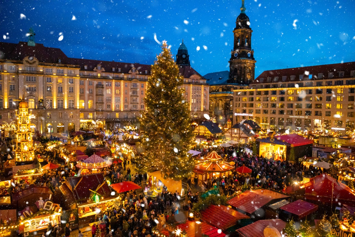Elegant Christmas market in Germany with twinkling lights and luxury travelers exploring festive stalls, curated by Amore Travel Designs, Fort Collins luxury travel advisor.