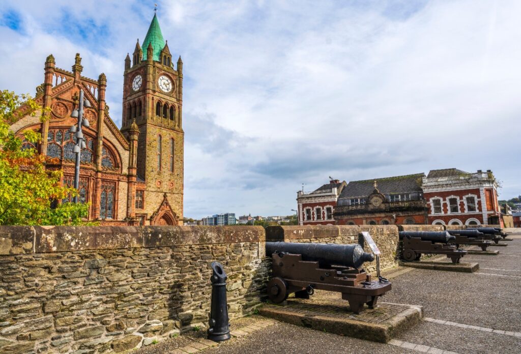 Historic Guildhall and cannons along Derry’s ancient city walls under soft Irish light — a blend of history and elegance captured for Ghostly Glamour Ireland, curated by Fort Collins luxury travel advisor Amore Travel Designs.