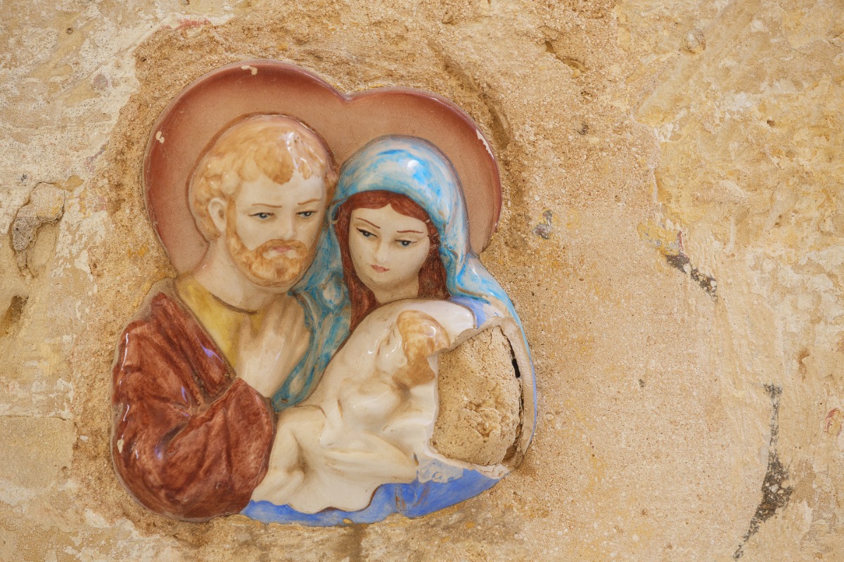 Traditional ceramic Holy Family artwork embedded in an aged limestone wall in Malta, reflecting the island’s religious heritage and cultural craftsmanship. Ideal inspiration for luxury cultural travel with Amore Travel Designs.