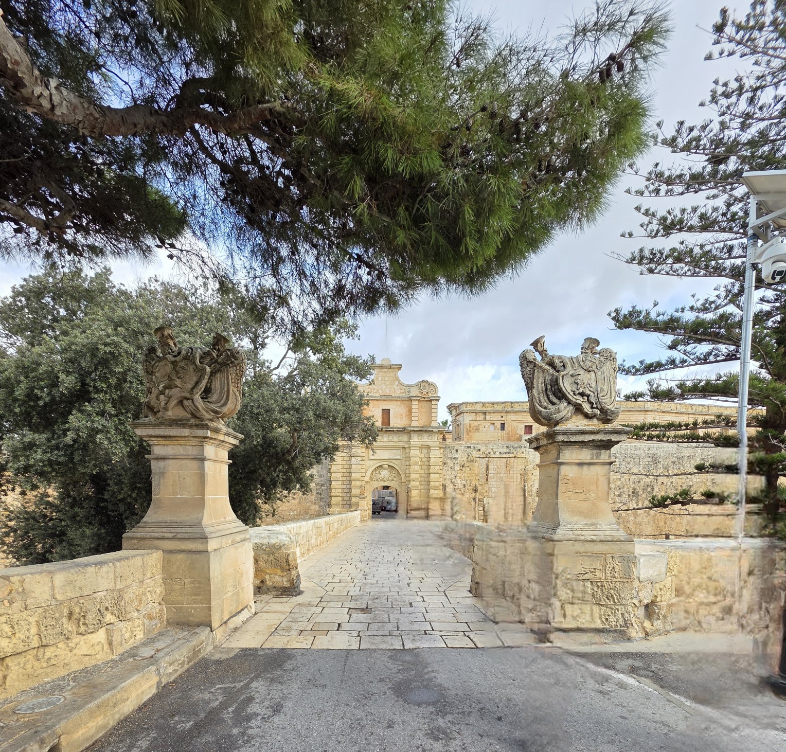 Cathy Rowland at the historic Mdina Gate in Malta, exploring medieval architecture during a luxury Europe scouting trip with Amore Travel Designs.