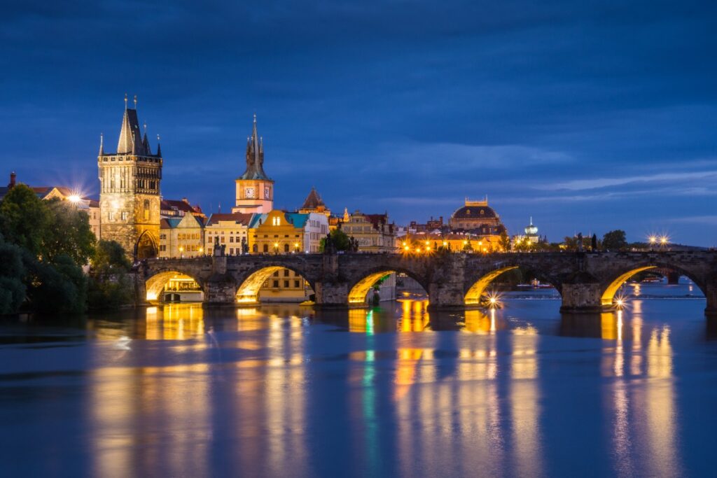 Prague’s Old Town Square at dusk, glowing with golden lights and historic architecture, capturing the romance of a European city break planned by a Fort Collins luxury travel advisor.