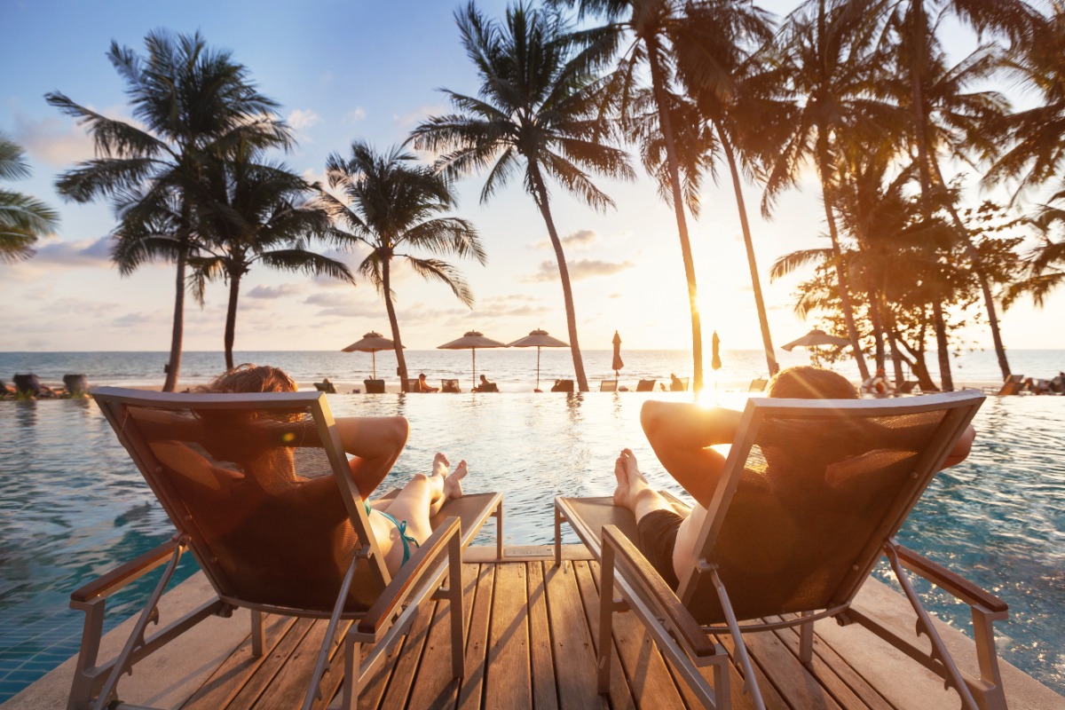 Luxury beachfront resort sunset with infinity pool and loungers, representing stress-free vacation planning by a Fort Collins luxury travel advisor
